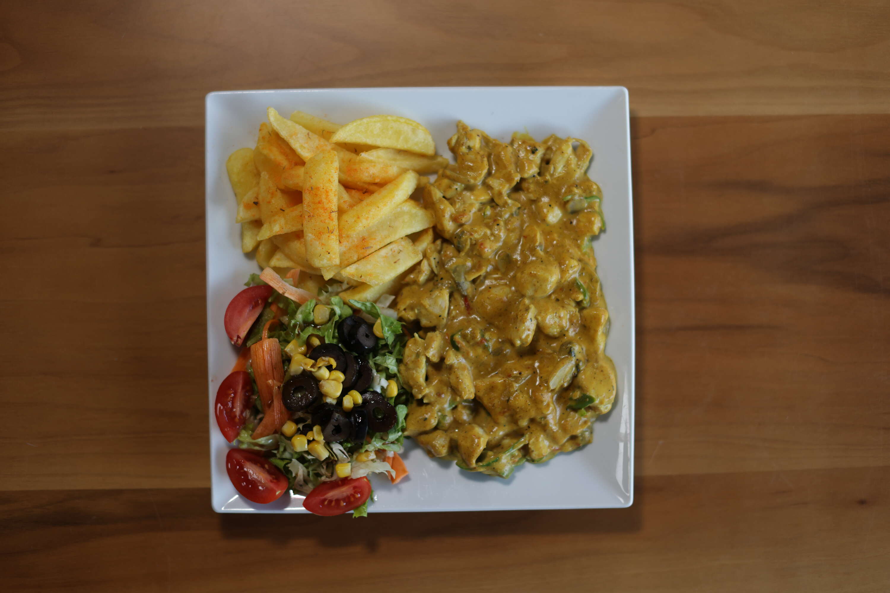 Curry chicken with fries and salad