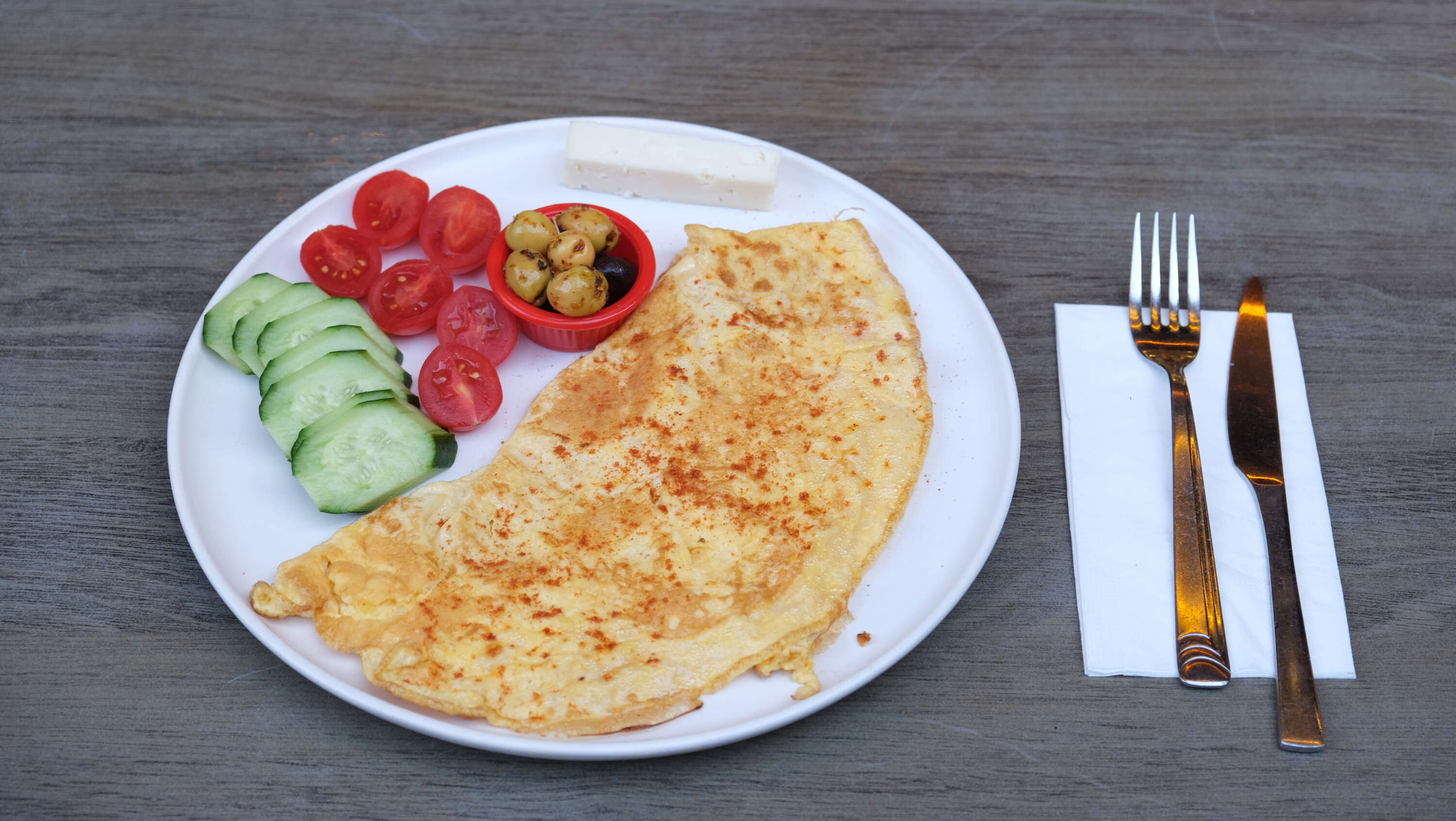 Plain omelette with white cheese, tomato, cucumber and olives
