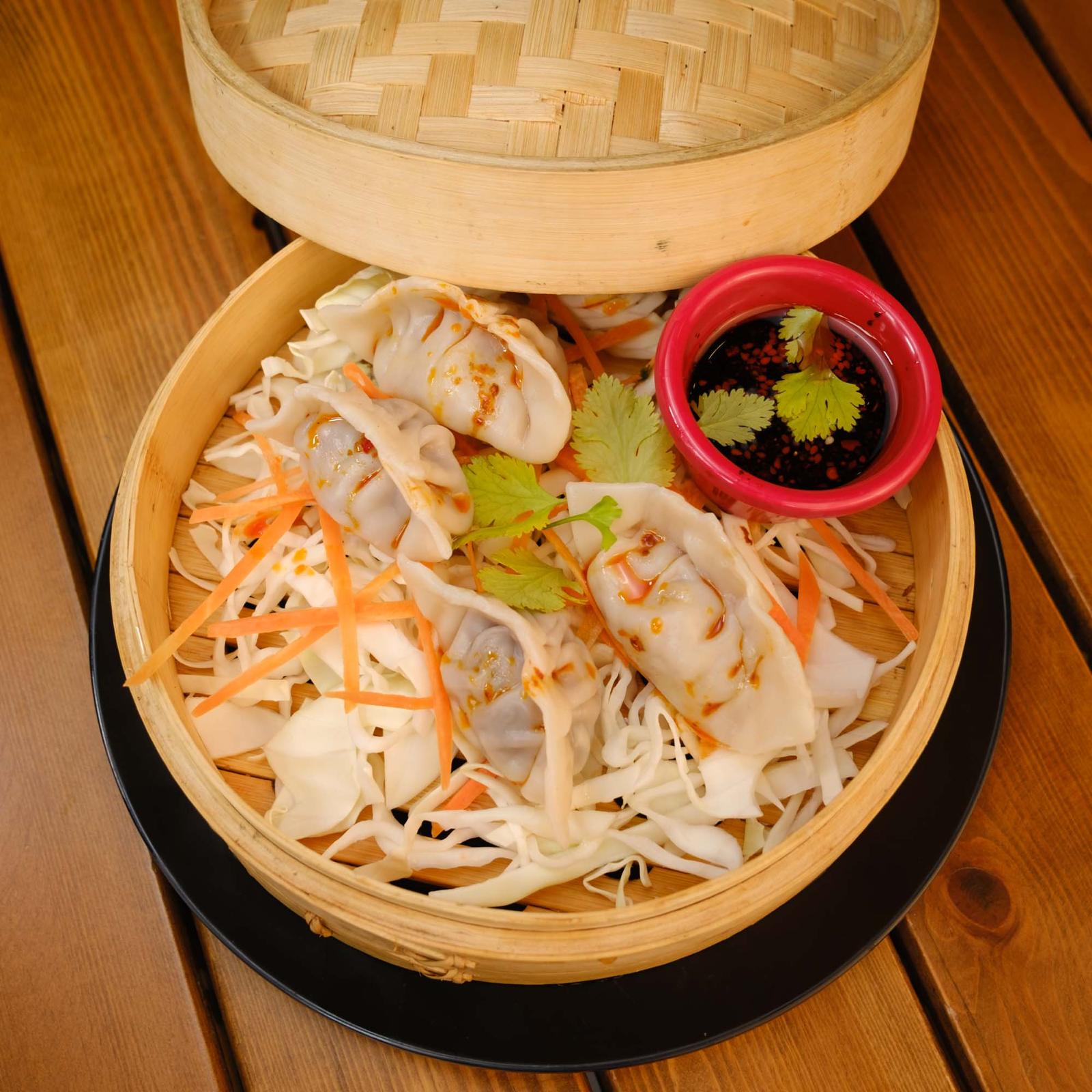 Steamed Chinese dumplings (4 pieces), served with sauce